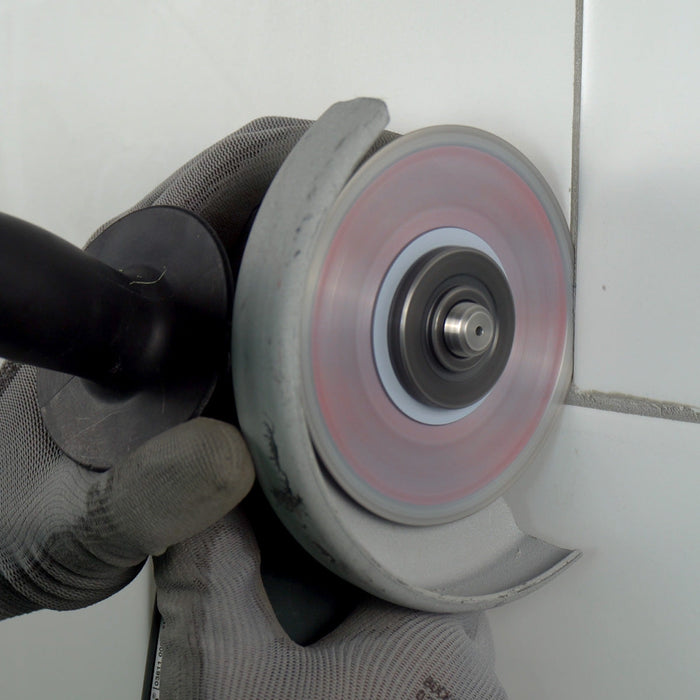 Worker using Cleaner 4 inch diamond blade on angle grinder to clean grout