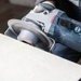 Person using a Bosch angle grinder on a concrete surface