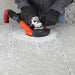 Contractor grinding concrete indoors with VORTEX dust guard attached to shop vac